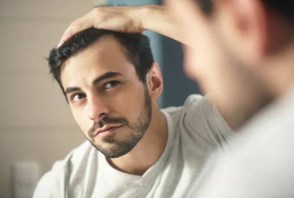 man checking for hair loss